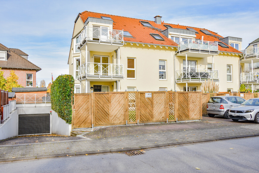 Hausansicht mit Tiefgarageneinfahrt - Moderne helle Eigentumswohnung mit großem Balkon, perfekter Raumaufteilung + Tiefgaragenstellplatz.