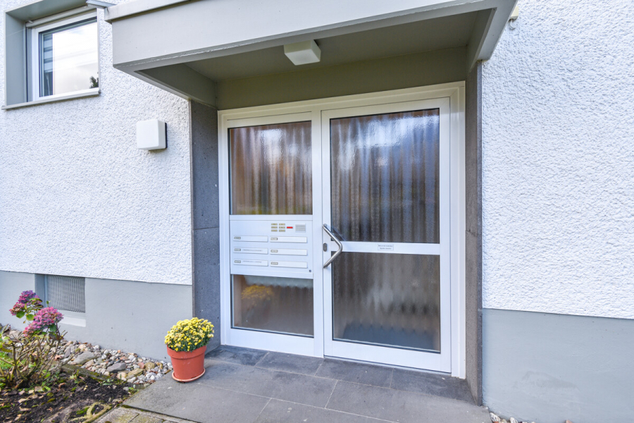 Hauseingang - Modernisiertes Wohnen mit Komfort – Drei Zimmer Loggia & Einbauküche.